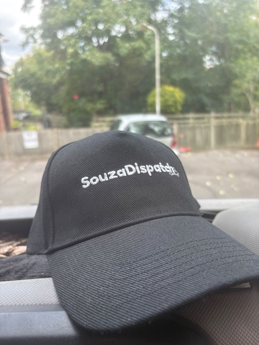 A SouzaDispatch cap on the van dashboard