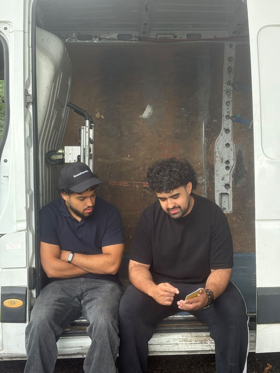 Two of the crew going through the job list at the back of the van